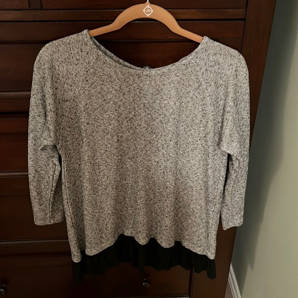 Silver tunic with black ruffle detailing at the bottom. Black ribbon insert back